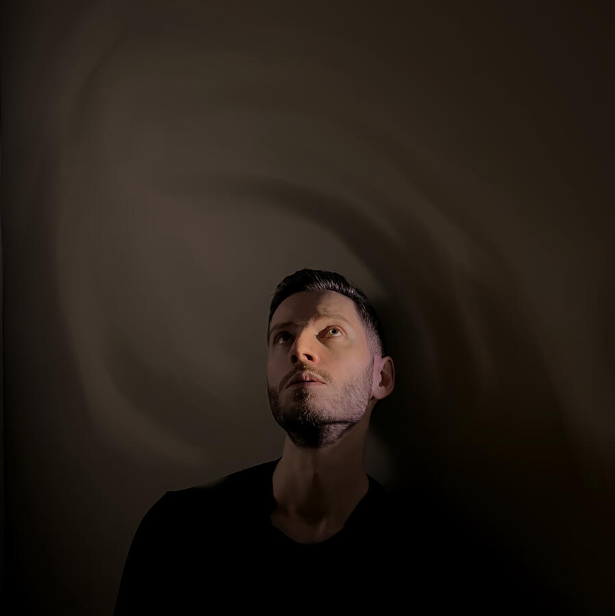 Artsy shot Eric's face in shadowy dark green lighting